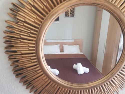 a mirror with a teddy bear in front of a bed at LUXURY APARTMENTS 2 in Nea Potidaea