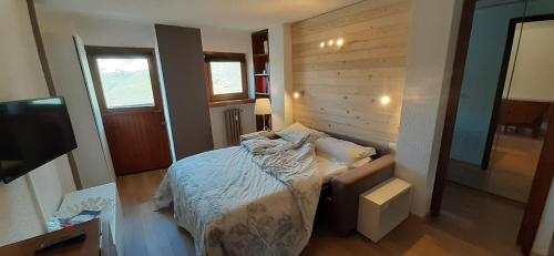 Un dormitorio con una cama y un televisor. en Matterhorn Studio Cervinia, en Breuil-Cervinia