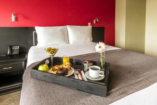 a tray of food on top of a bed at Urban Green Hotel & Suites in San José