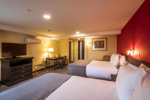 Urban Green Hotel & Suites tesisinde bir odada yatak veya yataklar