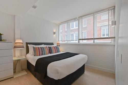 a bedroom with a large bed and a window at West Street by Aeria Apartments in London