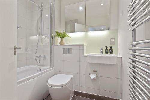 a white bathroom with a toilet and a shower at West Street by Aeria Apartments in London