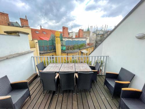 a wooden deck with a table and chairs on a balcony at Žatecká - Terrace Residence in the Old Town in Prague