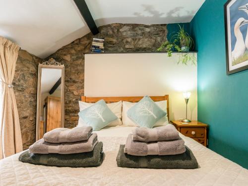 1 dormitorio con 1 cama con toallas en Carreg Lwyd, en Blaenau Ffestiniog