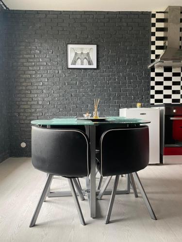 - une table à manger et 2 chaises dans la cuisine dans l'établissement Verdun, à Mantes-la-Jolie