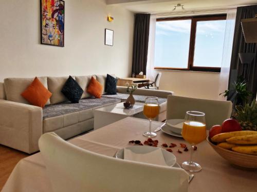 - un salon avec un canapé et une table avec des verres à vin dans l'établissement Sea View Suite, à Orašac