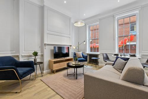 a living room with a couch and a tv at Gerrard Place by Aeria Apartments in London