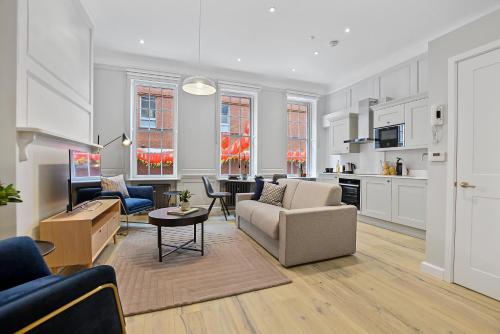 a living room with a couch and a table at Gerrard Place by Aeria Apartments in London