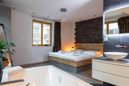 y baño con cama, bañera y lavamanos. en Apartment Lisa en Zell am See