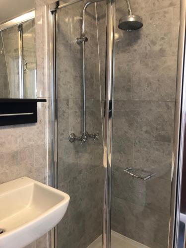 a bathroom with a shower, sink, and toilet at Plaza London Hotel in London