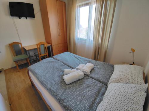 a bedroom with a bed with towels on it at Soko-Veljkovic-apartman in Soko Banja