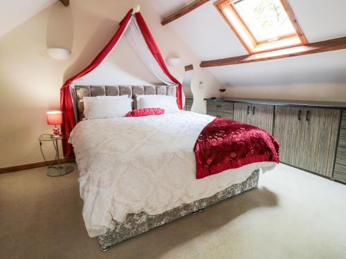 1 dormitorio con 1 cama grande con dosel rojo en St Hilda's Cottage, en Hinderwell