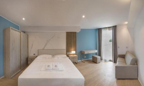 een slaapkamer met een groot wit bed en een bank bij Hotel Byron in Lerici