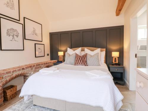 a large white bed in a bedroom with two lamps at Carver's Rest in Farnsfield