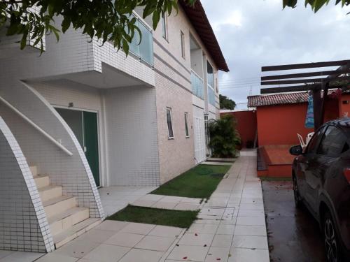 a house with a sidewalk next to a building at AP Comfort Feliz Aurora - Frente Praia do Ariramba in Mosqueiro