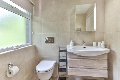 a bathroom with a sink and a toilet and a mirror at 3 Bed Private Bungalow Close to Amenities, Wifi, Parking by Ark SA in Sheffield
