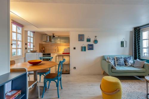 una cucina e un soggiorno con tavolo e sedie di La maison Confidentielle - plein centre historique - 2 chambres - 4 pers a Honfleur