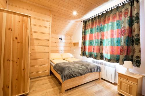 sypialnia z łóżkiem w drewnianym pokoju w obiekcie DW KINGA & DOMKI na Granicznej z jacuzzi w mieście Kacwin