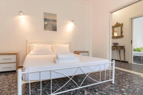 un letto bianco con lenzuola e cuscini bianchi di Modern apartment 1 minute from Remataki beach a Samos