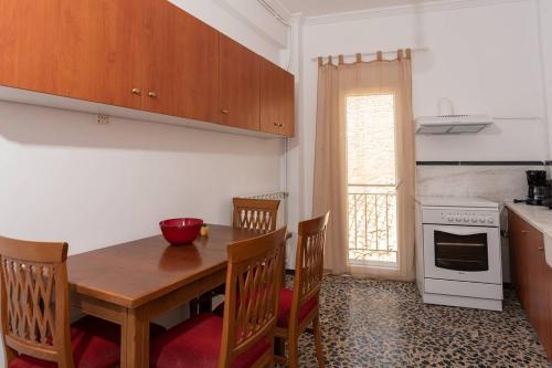 uma cozinha com uma mesa e cadeiras de madeira e um fogão em Modern apartment 1 minute from Remataki beach em Samos