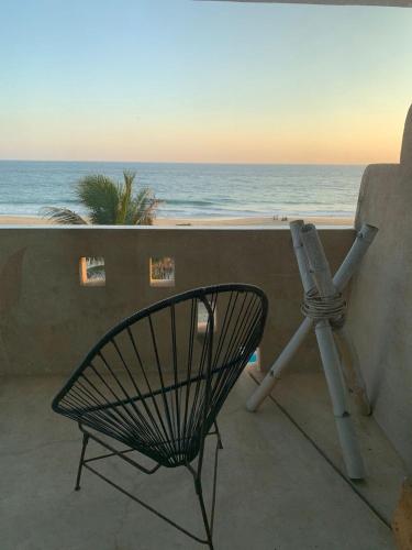 a chair and a telescope on a balcony overlooking the ocean at Condominio Agave del Mar in Coyuca