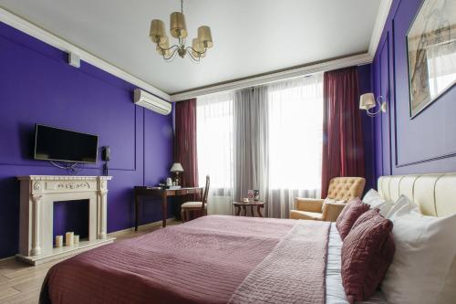 1 dormitorio con paredes moradas, 1 cama y 1 silla en Marel Hotel, en San Petersburgo