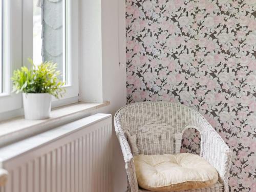 a wicker chair in a room with pink floral wallpaper at Beautiful Holiday Home in Winterberg near Ski Slopes in Winterberg