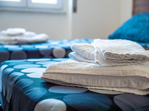 a pile of towels sitting on top of a bed at Girastrittue Colobraro in Colobraro