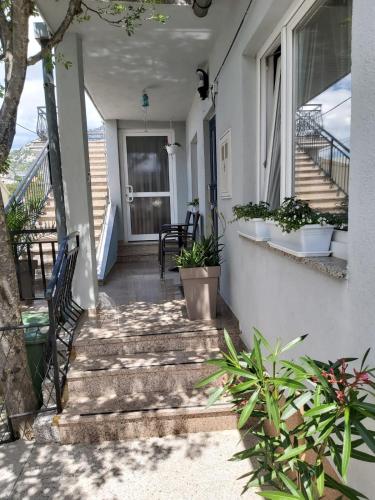 a porch of a house with stairs and plants at Apartman Klara in Karlobag