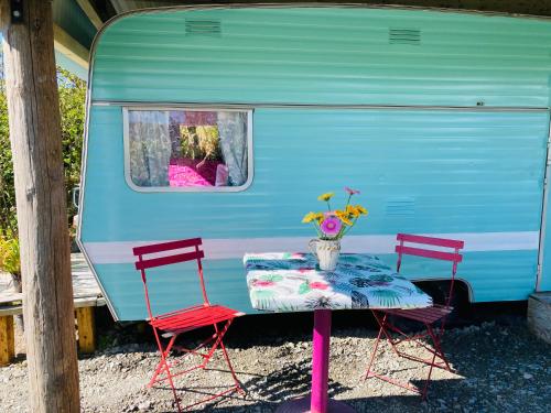 ヴァレンティア島にあるRetro Caravans at Valentia Island Escapeの青いトレーラーの横にテーブルと椅子2脚