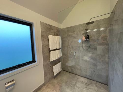 La salle de bains est pourvue d'une douche avec une porte en verre. dans l'établissement NEST@Waterton Hall, à Rowella