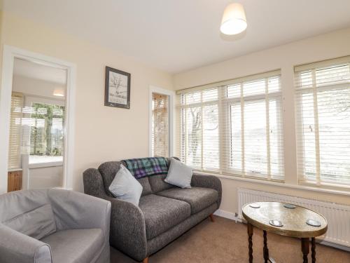 a living room with a couch and a table at Balnaird Farmhouse in Strathpeffer