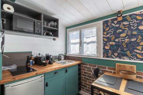 a small kitchen with a sink and a window at Marée haute - nice refresh studio in a full center - Netflix - wifi - in Honfleur