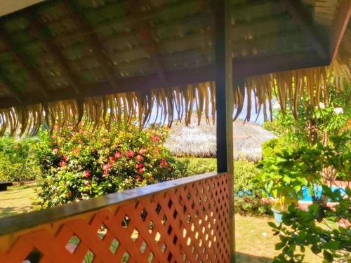 a wooden fence with a roof and some flowers at HUAHINE - Bungalow Ylang Ylang in Fare