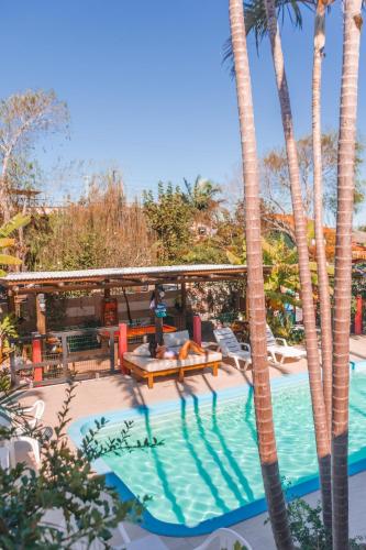 a pool at a resort with palm trees at Hotel Ferrugem Eco Village in Garopaba