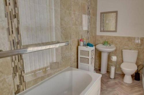 a bathroom with a tub and a toilet and a sink at Pomfret House, in Burnley Central, Ideal for Contractors with Free Parking and Wifi in Burnley