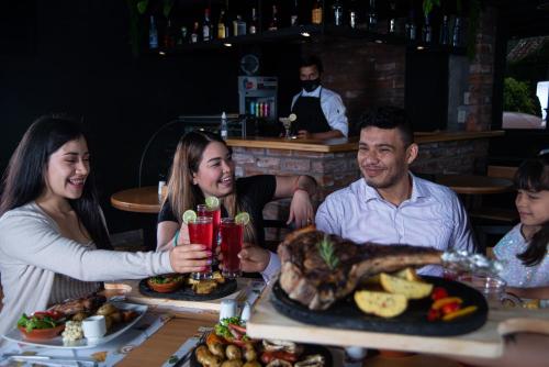 a group of people sitting at a table with food at Hotel Tungurahua in Baños
