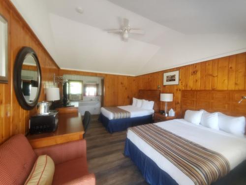 a hotel room with two beds and a couch at Bayview Lakefront Inn in Saint Ignace