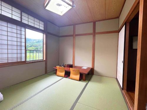 una habitación vacía con una mesa y dos sillas en Guest House Nakamura, en Ama