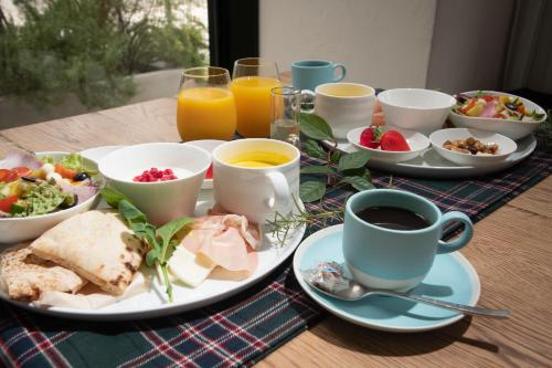 a table topped with plates of food and cups of coffee at Hotel It Osaka Shinmachi in Osaka