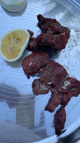 a plate of food with a piece of food and a lemon at Oriental Nights Rest House in Al Wāşil
