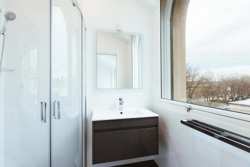 bagno con lavandino e doccia in vetro di Salamanca Galleria Apartments a Hobart