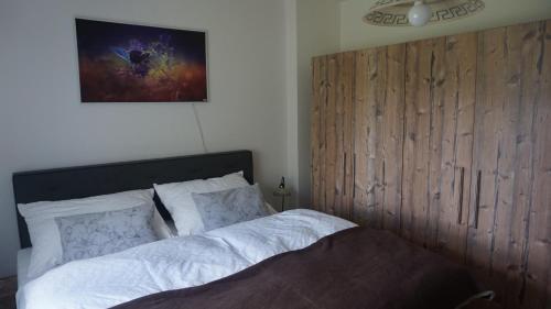 Un dormitorio con una cama con cabecero de madera. en Almhaus Frierss, en Verditz