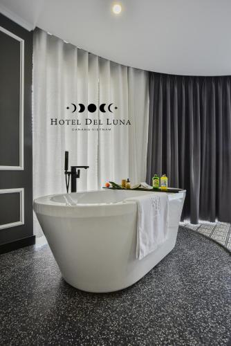 a bath tub in a bathroom with a hotel delounge at Hotel Del Luna Boutique in Da Nang