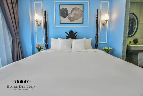 a blue bedroom with a large bed and a bathroom at Hotel Del Luna Boutique in Da Nang