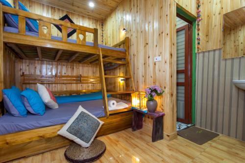 a bedroom with bunk beds in a log cabin at Little View Homestay in Sa Pa