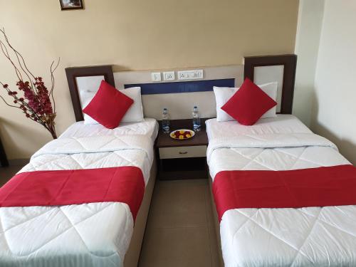 two beds sitting next to each other in a room at Hotel City Garden in Madgaon