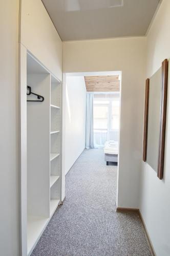 a hallway with white walls and a room with a bed at Vila Kastytis in Nida