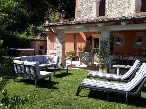 un patio con 2 sillas, una mesa y sillas en B&B L'Usignolo, en Ascoli Piceno