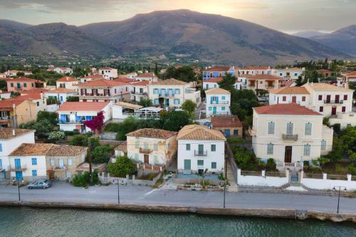 a town on the water with mountains in the background at Galaxa Mansion in Galaxidhion